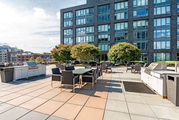 A patio with a table and chairs is in front of a large building.